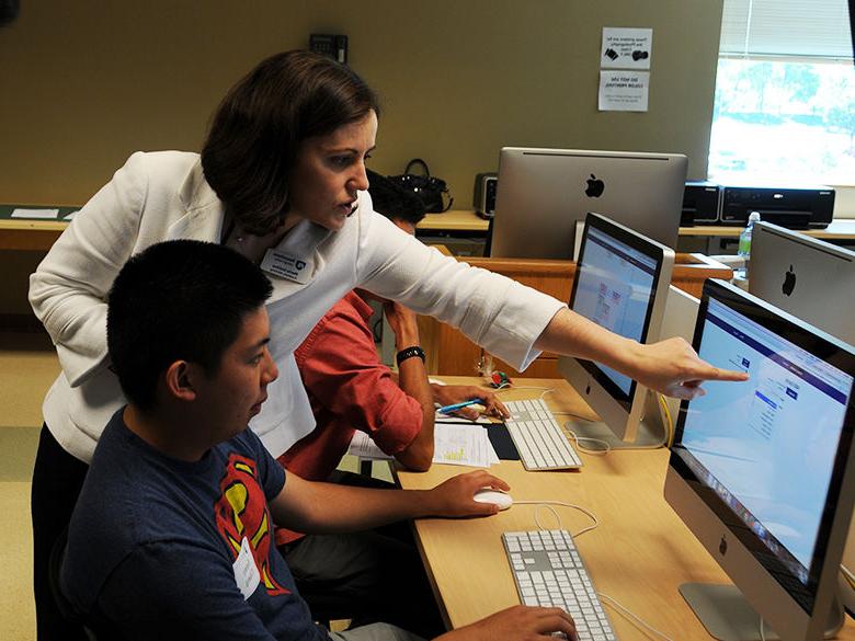 professor assisting a student while they work on the computer